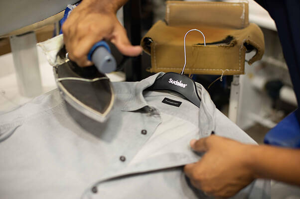 Professional pressing of a shirt at Sudsies Dry Cleaning