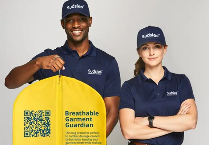 Professional Sudsies Dry Cleaning team presenting expertly cared-for shirts with premium garment protection