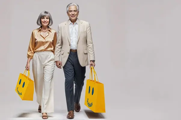 Elegantly dressed couple carrying Sudsies bags after professional shirt dry cleaning and garment care